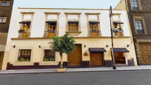 a building with windows and doors on a street at Casa Donceles Apartments and Suites, Alojamientos ideales para familias y grupos in Mexico City