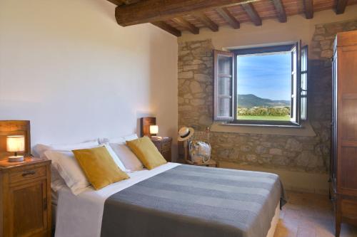 a bedroom with a large bed and a window at Podere La Querciola in Guardistallo