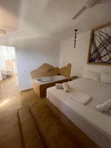 a bedroom with two beds and a bath tub at Villa Aigli in Anafi