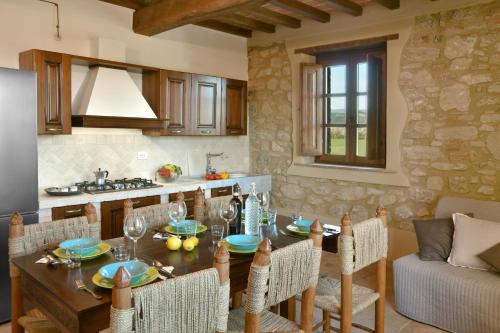 a kitchen and dining room with a wooden table and chairs at Podere La Querciola in Guardistallo