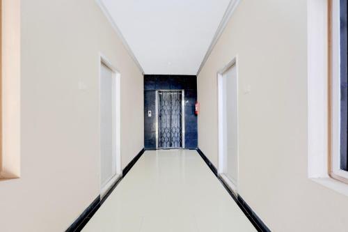 a hallway with white walls and a door at Super Collection O Bhanugudi Junction Kakinada Formerly Stay Inn Luxury in Kākināda