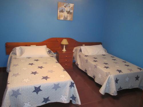 two beds in a room with blue walls at Hotel Chola in Dorna