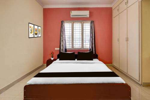 a bedroom with a bed and a red wall at Super Collection O Bhanugudi Junction Kakinada Formerly Stay Inn Luxury in Kākināda