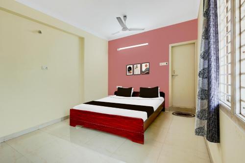 a bedroom with a bed and a pink wall at Super Collection O Bhanugudi Junction Kakinada Formerly Stay Inn Luxury in Kākināda