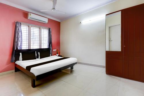 a bedroom with a bed and a red wall at Super Collection O Bhanugudi Junction Kakinada Formerly Stay Inn Luxury in Kākināda