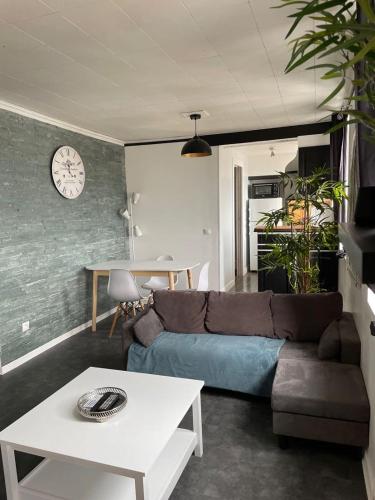 un salon avec un canapé et une table dans l'établissement Appartement calme, à Saint-Valery-en-Caux
