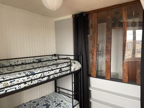 deux lits superposés dans une chambre avec fenêtre dans l'établissement Appartement calme, à Saint-Valery-en-Caux