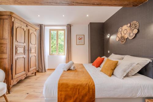 - une chambre dotée d'un grand lit avec des oreillers orange et blancs dans l'établissement La Roseraie - Disney 30 minutes, à Saint-Augustin