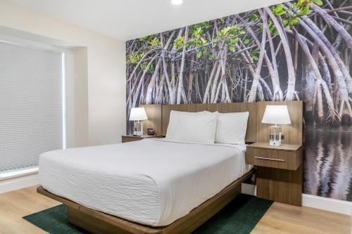 a bedroom with a bed and trees mural at The Fold Hotels Orlando in Orlando
