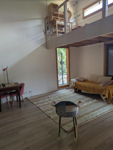- un salon avec une mezzanine et une table dans l'établissement Maison bois au calme, à Ailhon
