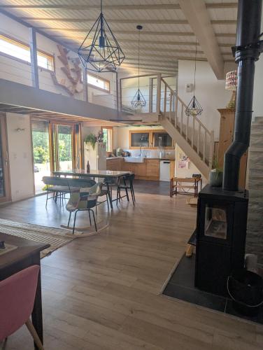Elle comprend un grand salon avec un poêle à bois. dans l'établissement Maison bois au calme, à Ailhon