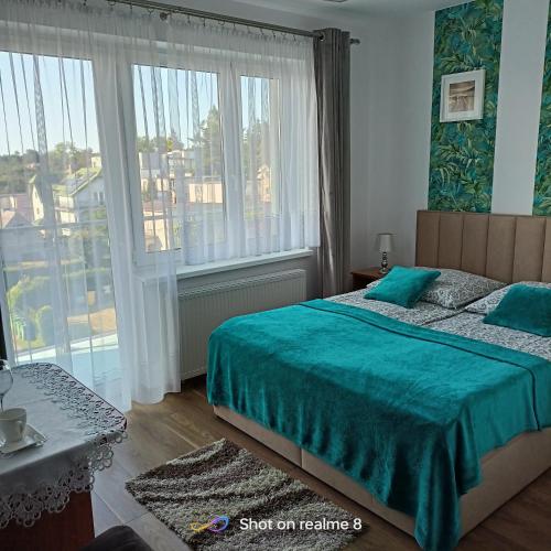 Un dormitorio con una cama y una ventana grande. en Villa Turkus, en Jastrzębia Góra