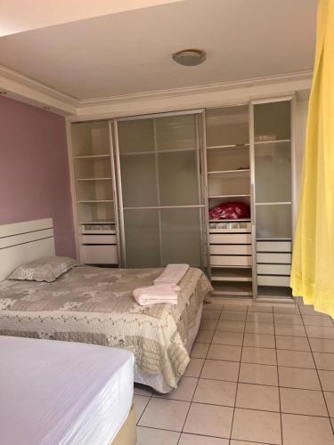 two beds in a room with closets at Ampla Casa Duplex com 4 suítes in Teresina