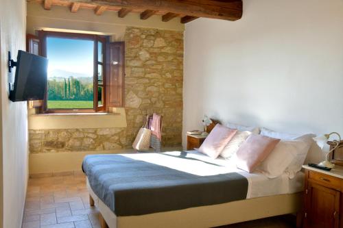 a bedroom with a bed with a tv and a window at Podere La Querciola in Guardistallo