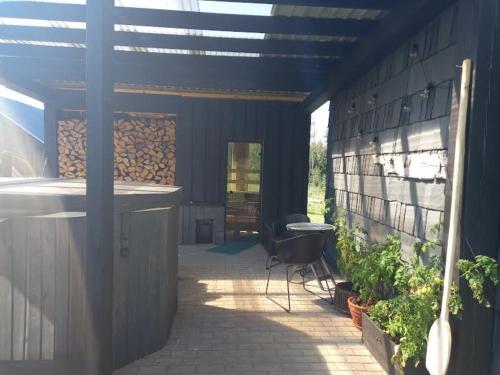 a patio with a table and a chair in a building at Arakaoja saunamaja in Nepste