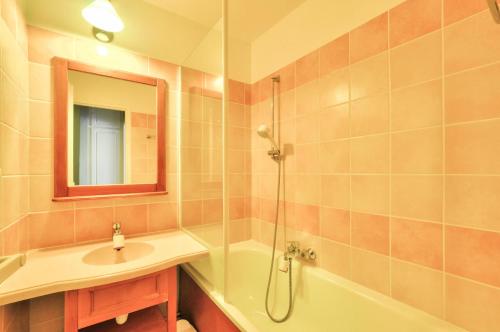 une salle de bain avec une baignoire, un lavabo et une douche dans l'établissement La résidence du Lac - maeva Home - Appartement 2 pièces 4 personnes - Sélection MAE-5243, à Monflanquin