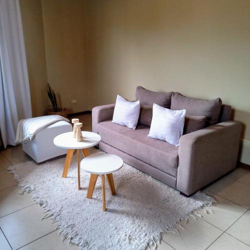 a living room with a couch and two tables at Buona Vita Departamento Alto Dorrego - Mendoza in Guaymallen