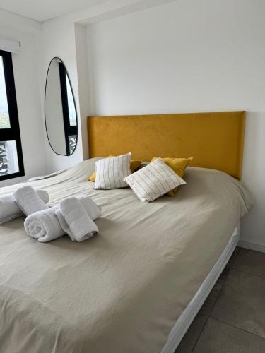 a large bed with white pillows on top of it at Departamento Confort AVI in Salta