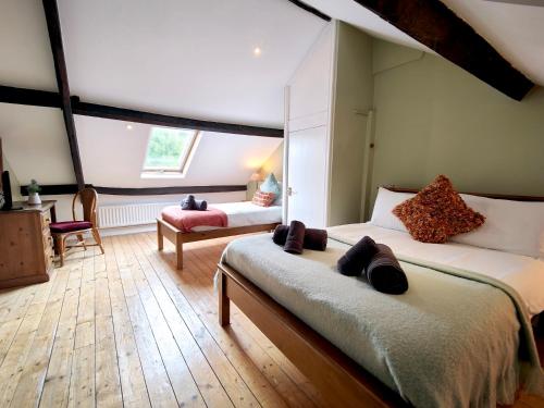 a bedroom with two beds and a chair and a window at Bush Nook House in Brampton