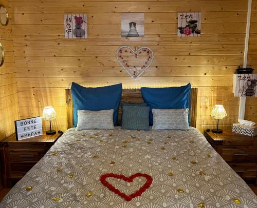 a bedroom with a bed with two hearts on the wall at Les Chalets de marie 2 - Vue mer, Jacuzzi SPA privatif dans le chalets Sans vis à vis in Saint-Denis
