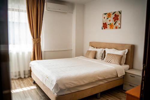 a bedroom with a bed and a window at Casa Soarelui in 2 Mai