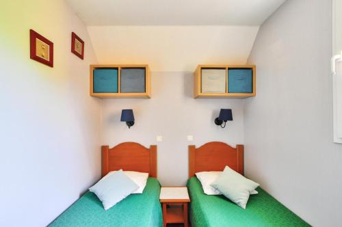 a room with two beds and two windows at La résidence du Lac - maeva Home - Maison 3 pièces 6 personnes - Prestige MAE-1083 in Monflanquin