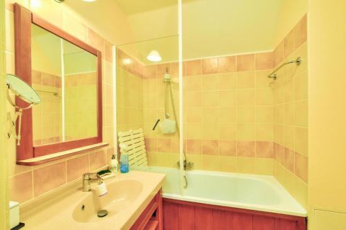 a bathroom with a tub and a sink and a mirror at La résidence du Lac - maeva Home - Maison 3 pièces 6 personnes - Prestige MAE-1083 in Monflanquin