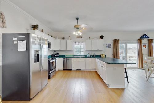 a kitchen with white cabinets and a stainless steel refrigerator at Bayside View in Ocean City