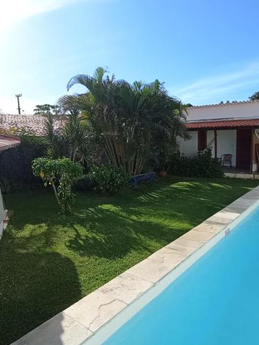 a yard with a swimming pool next to a house at Pousada Casa Do Cocotier in São Miguel do Gostoso