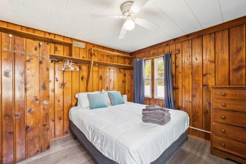 a bedroom with wood paneled walls and a bed at Cozy & Easy - Steps to the Sand in Oscoda