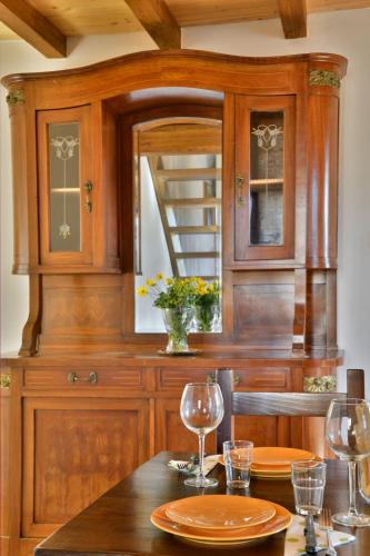 a kitchen with wooden cabinets and a table with wine glasses at Podere La Querciola in Guardistallo