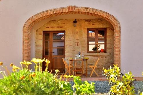 a patio with an archway with a table and chairs at Podere La Querciola in Guardistallo