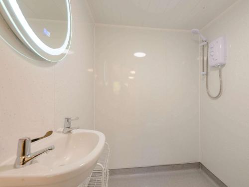 a white bathroom with a sink and a shower at 1 Bed in Conwy 79464 in Conwy
