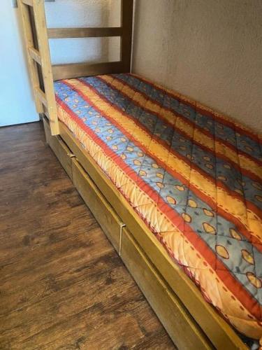 Ce lit se trouve dans un dortoir doté de parquet. dans l'établissement Résidence Serac - CHARMANT STUDIO POUR 3 PERSONNES BIEN EQUIPE AVEC BALCON EXPOSE SUD MAE-7774, à Val Thorens