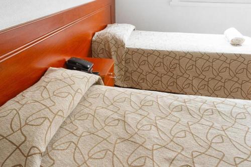 a bedroom with two beds and a phone on a table at Hotel Traful in Mar del Plata