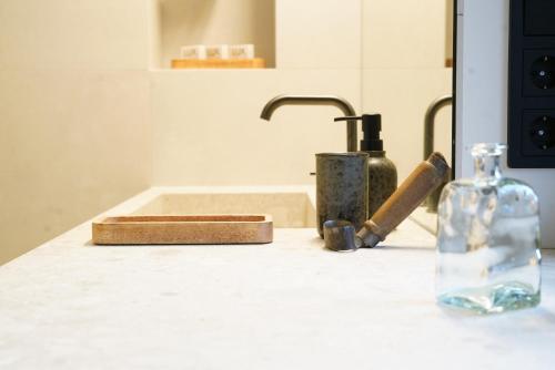 a counter top with a sink and a bottle on it at Design Boutique Apartments Weissensee in Weissensee