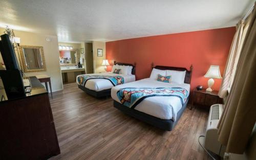 a hotel room with two beds and a red wall at Parry Lodge in Kanab