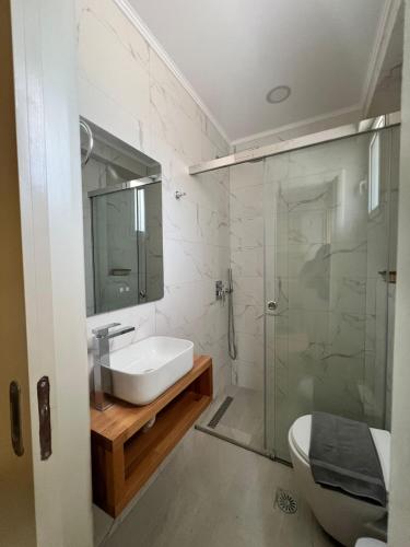a bathroom with a sink and a glass shower at Athina Rooms in Himare