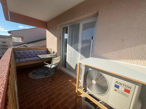un balcon d'appartement avec un ventilateur et un canapé dans l'établissement Studio climatisé, refait à neuf, à Hyères