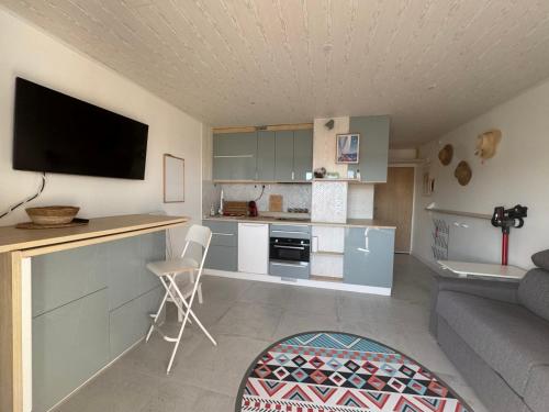 Il comprend une petite cuisine et un salon avec un canapé. dans l'établissement Studio climatisé, refait à neuf, à Hyères