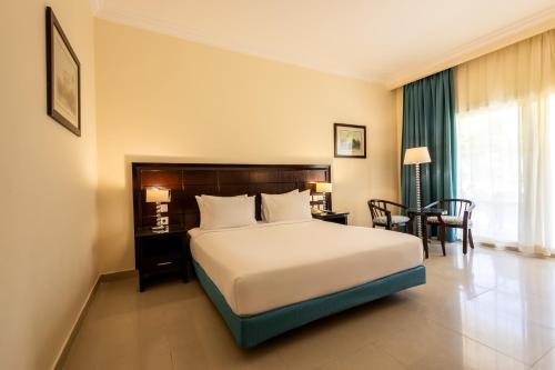 a hotel room with a bed and a table and chairs at Sierra Sharm El Sheikh in Sharm El Sheikh