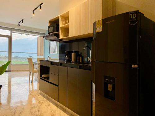 a kitchen with a black refrigerator in a room at Muralla by Wynwood House in Cartagena de Indias