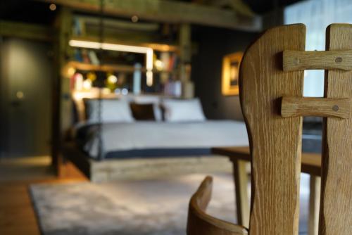 a bedroom with a bed and a wooden chair at Design Boutique Apartments Weissensee in Weissensee