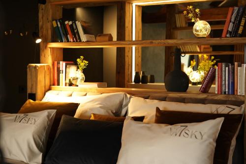 a room with a row of pillows and a shelf with books at Design Boutique Apartments Weissensee in Weissensee