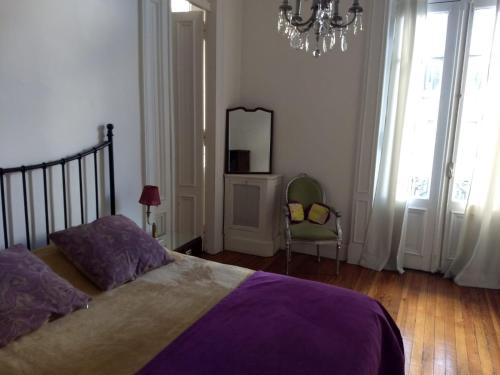 a bedroom with a bed and a mirror and a chair at Refugio Francés en Buenos Aires in Buenos Aires