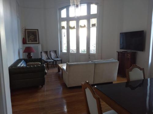 a living room with a couch and a tv at Refugio Francés en Buenos Aires in Buenos Aires
