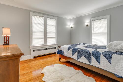 a bedroom with a bed and two windows at 5 Mi to Beaches Historic Apartment in Westerly! in Westerly