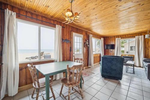 a dining room with a table and chairs at Lake Views with Big Windows & Bath in Oscoda