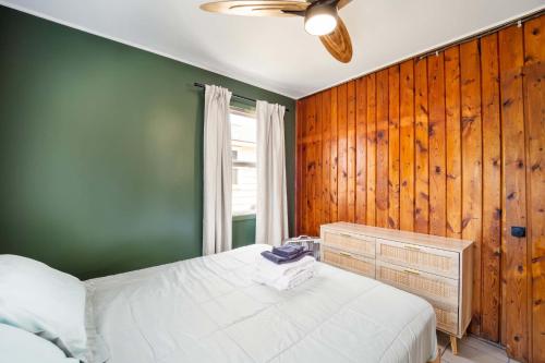 a bedroom with a white bed and a green wall at Lake Views with Big Windows & Bath in Oscoda