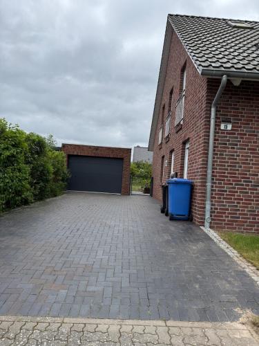 a garage with a brick building with a garage door at Doppelhaushälfte 125m2 3 Zimmer 2 Badezimmer Küche 5 Schlafplätze nähe Hamburg in Stelle